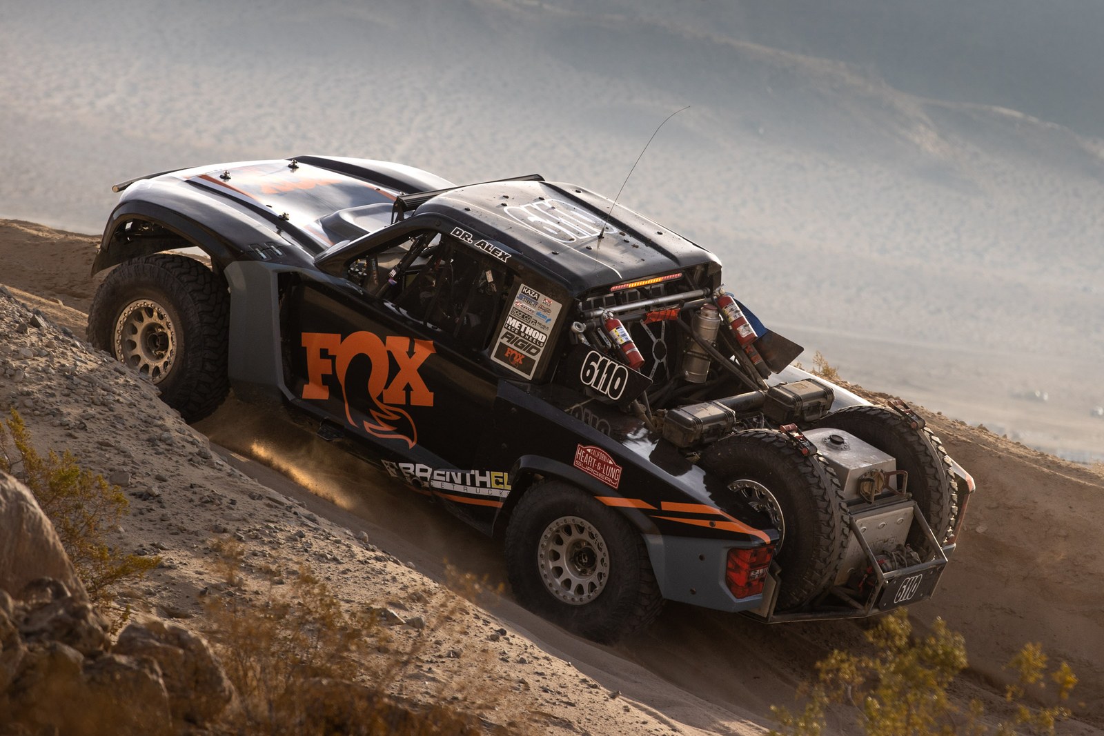 Brenthel trophy truck No. 6110 cresting a desert rise, King of the Hammers 2025